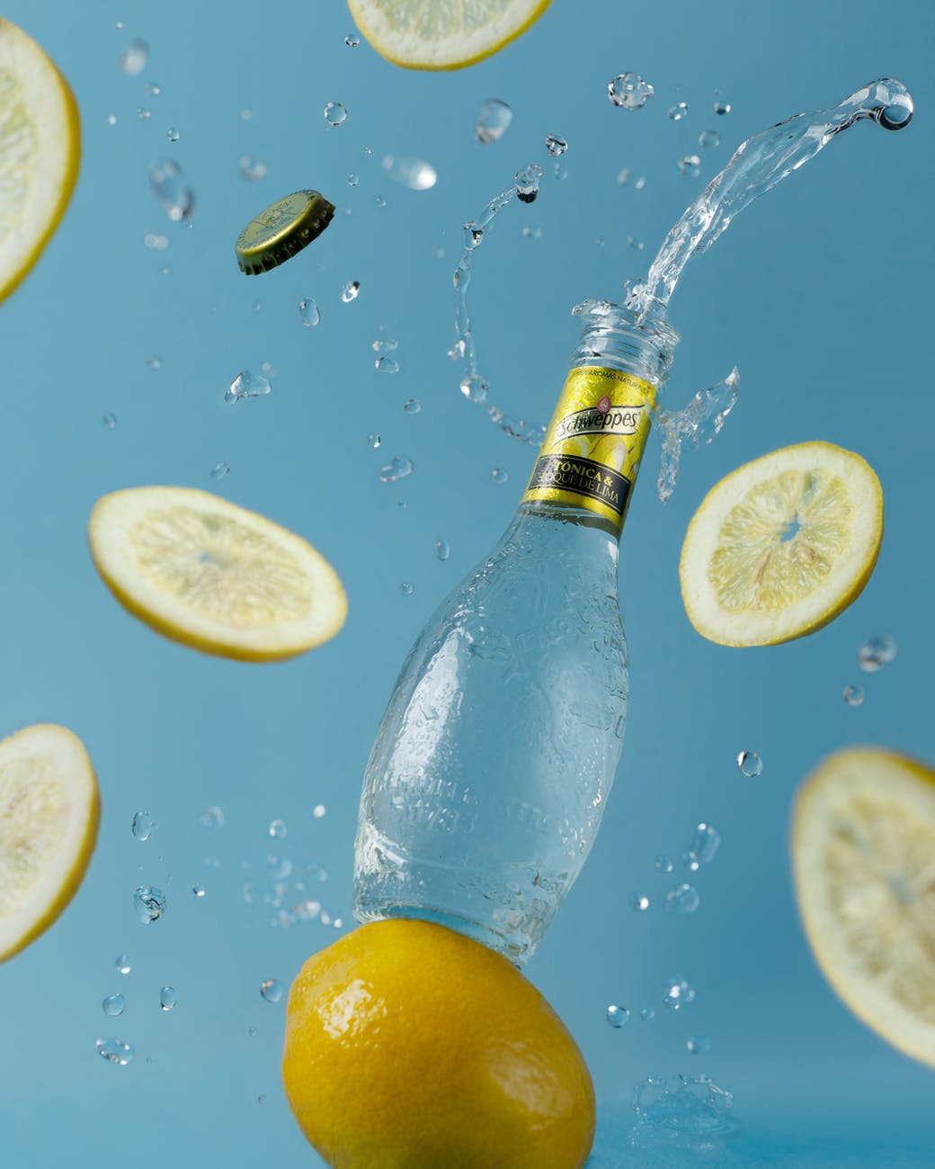 opened soft drink bottle near flying lemon slices
